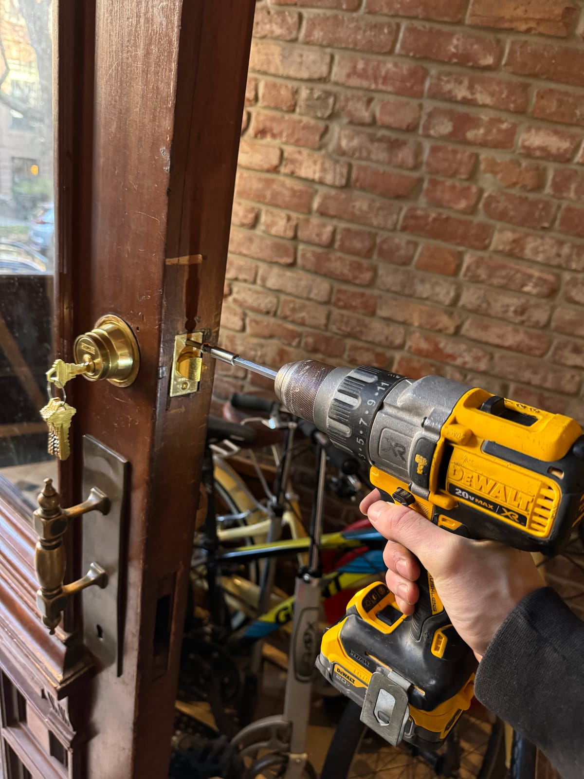Locksmith installing a high-security brass deadbolt on a Bronx door
